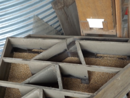 En blanc, c'est la trappe d'arrivée du grain qui arrive au milieu du plateau triangulaire