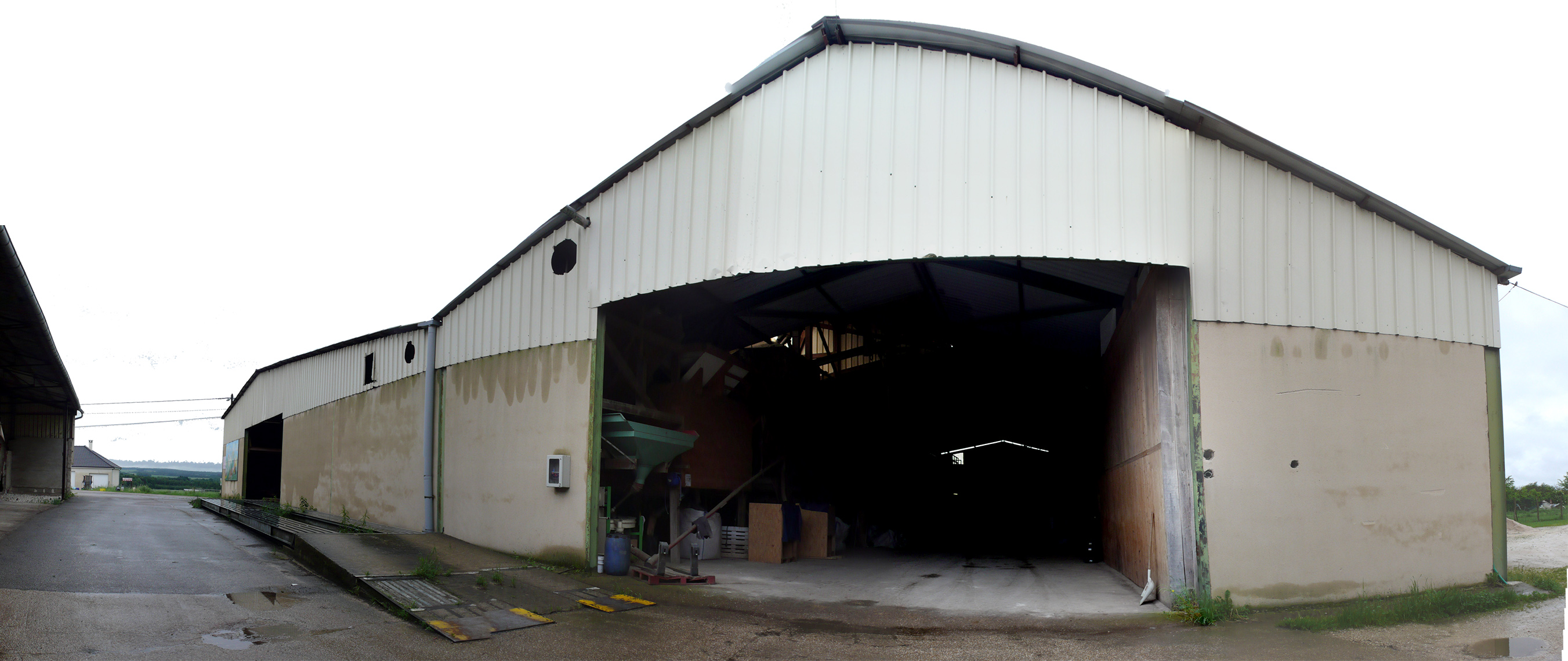 Vue de l'extérieur du hangar, depuis la cour. Le second hangar mitoyen est dédié aux machines et outils agricoles (et celui de l'autre côté de la cour est un stockage à plat pour le grain)