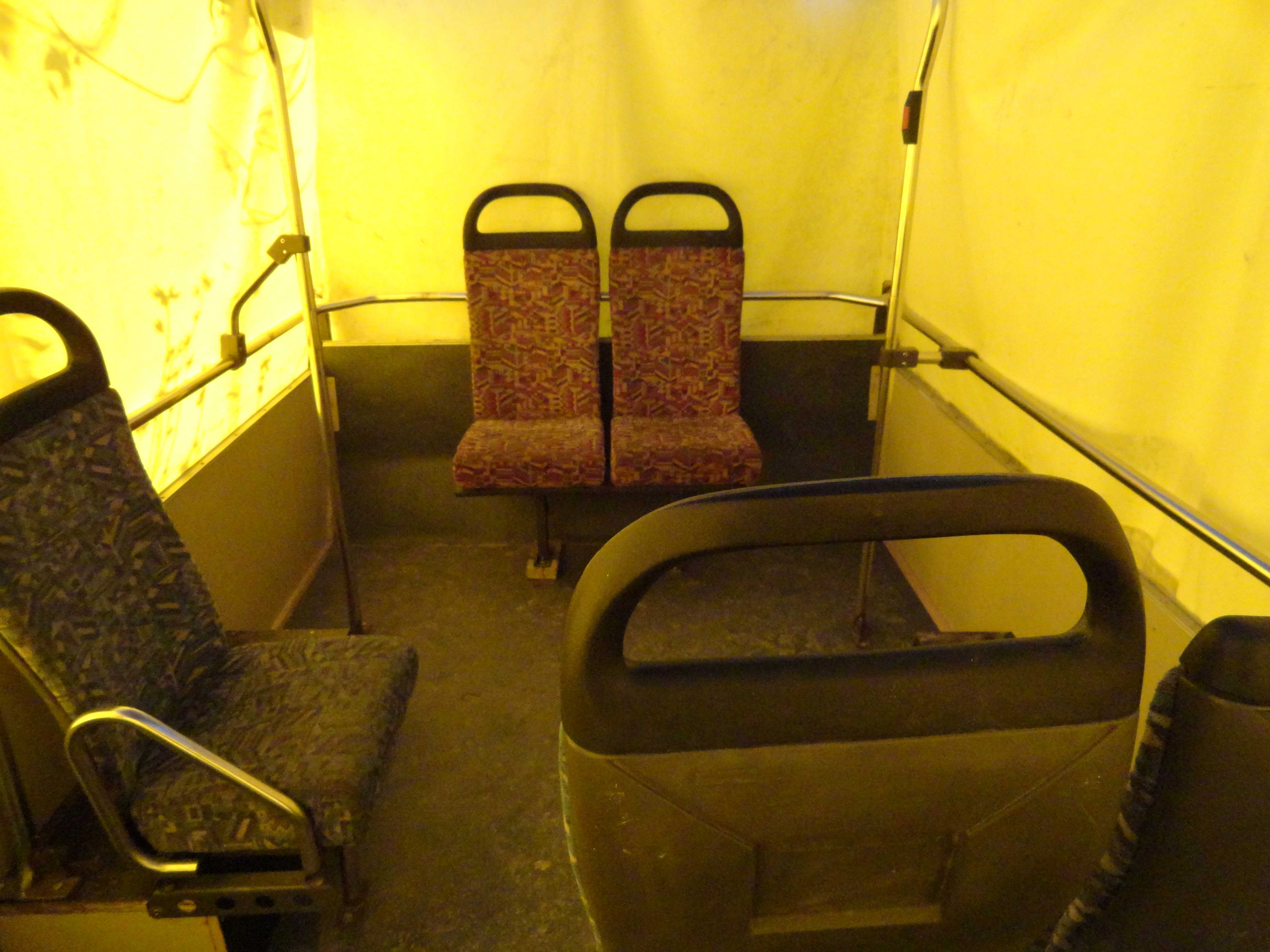 On remarque à l'intérieur de la caravane, les sièges de bus et les barres de maintient