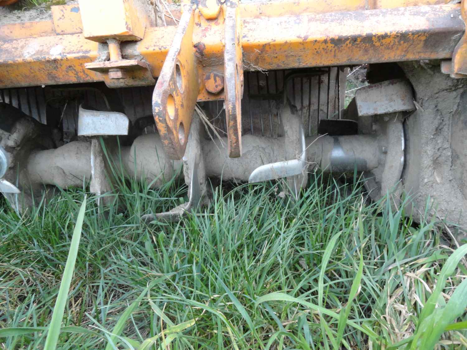 les dents de l’ancien rotovator sont actionnées en sens inverse, afin de projeter la terre sur la grille, visible à l’arrière.